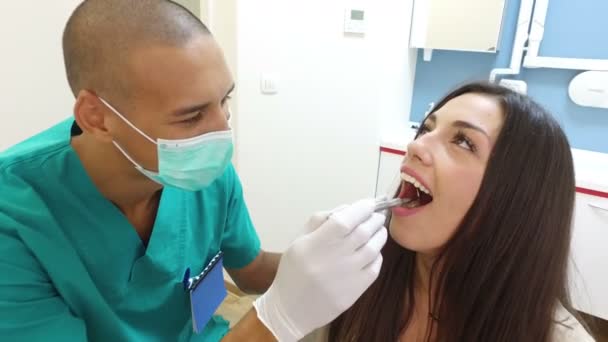 Assistente examinando dentes de mulher — Vídeo de Stock