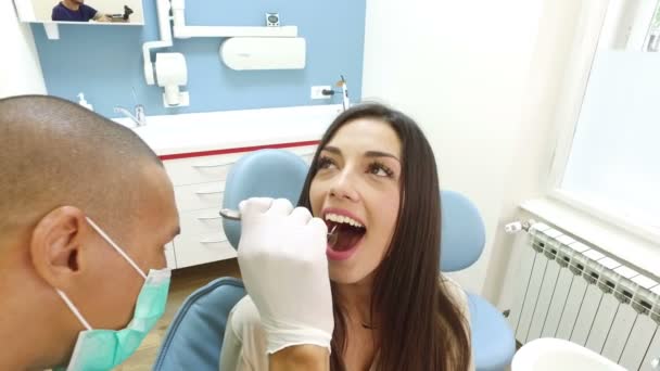 Asistente examinando los dientes de la mujer — Vídeo de stock