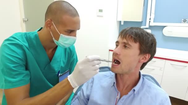 Zahnarzthelferin untersucht Zähne des Patienten — Stockvideo