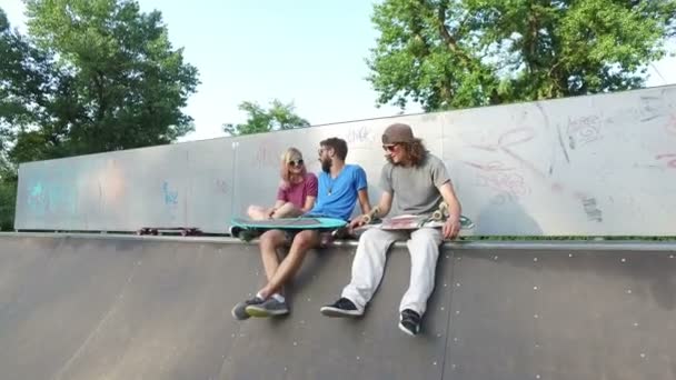 Vrienden zitten op een helling in skatepark — Stockvideo