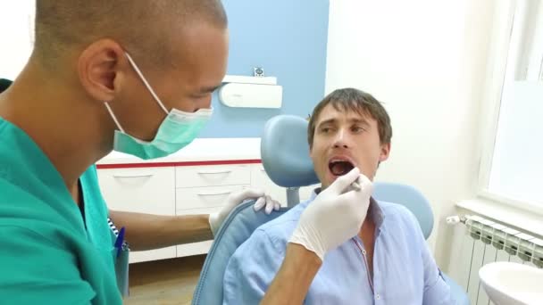 Assistente dentale che esamina i denti del paziente — Video Stock