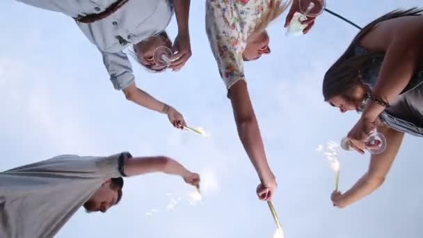 Amigos saludando con velas de fuegos artificiales — Vídeo de stock