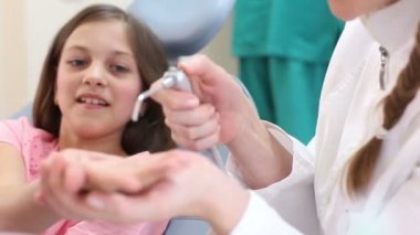 Kız dişçi gösteren aletler