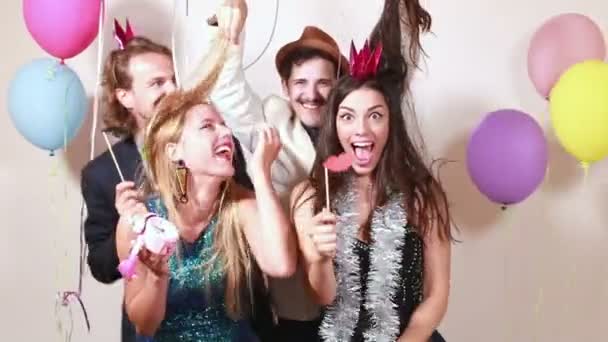 Amigos se divertindo na cabine de fotos da festa — Vídeo de Stock