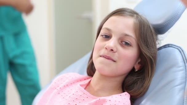 女孩坐在牙医的椅子上 — 图库视频影像