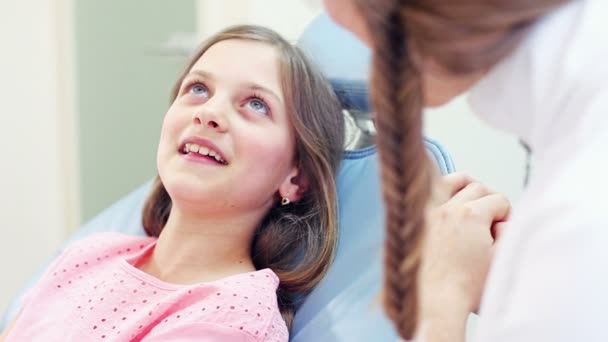 Девушка сидит в стоматологическом кресле — стоковое видео
