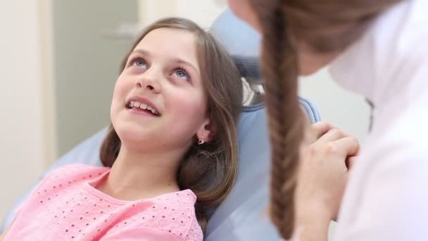 女孩坐在牙医的椅子上 — 图库视频影像