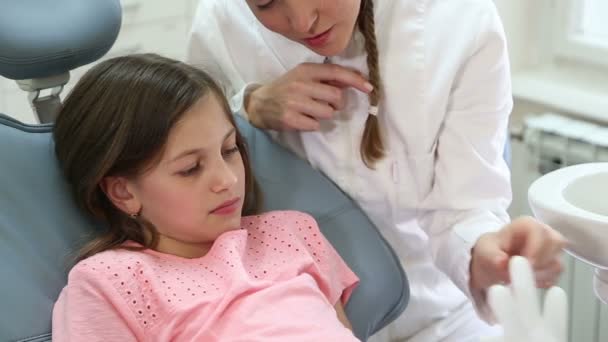 Дівчина і стоматолог грають з гумовою рукавичкою — стокове відео