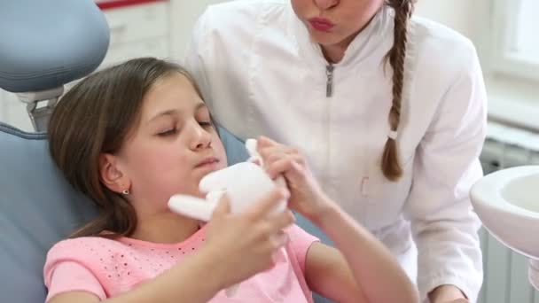 Menina e dentista brincando com luva de borracha — Vídeo de Stock