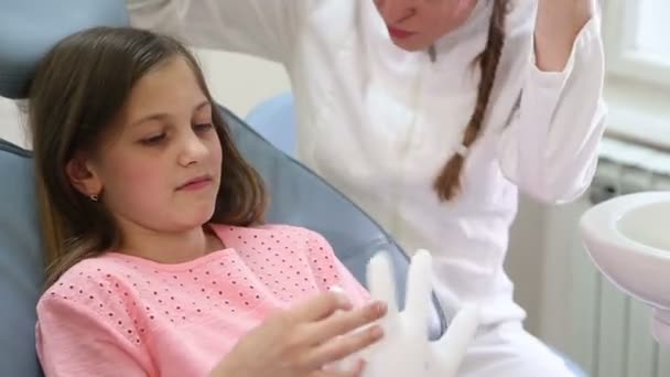 Chica y dentista jugando con guante de goma — Vídeo de stock