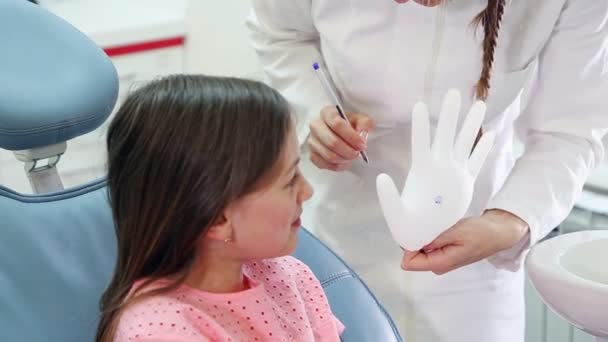 Chica y dentista jugando con guante de goma — Vídeo de stock