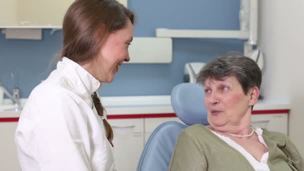 Стоматолог разговаривает с пожилым пациентом — стоковое видео