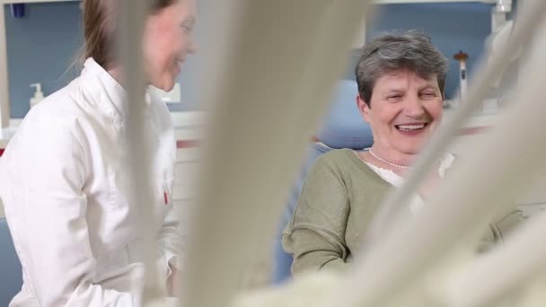 Стоматолог разговаривает с пожилым пациентом — стоковое видео