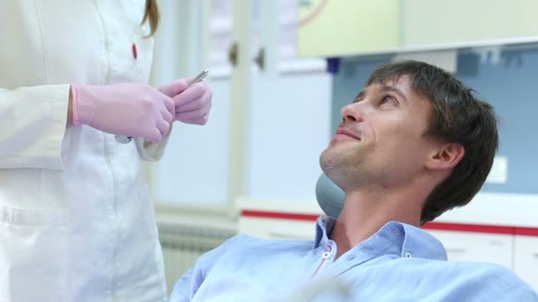 Пациент проходит обследование у стоматолога — стоковое видео