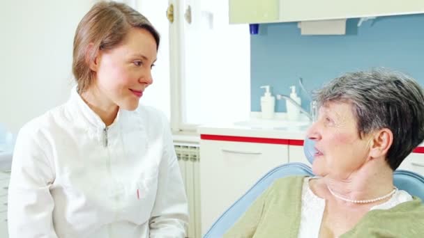 Стоматолог і пацієнт похилого віку розмовляє — стокове відео