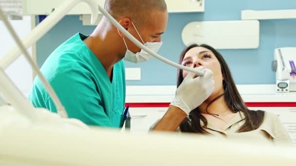 Cirujano dental tratando los dientes de la mujer — Vídeos de Stock