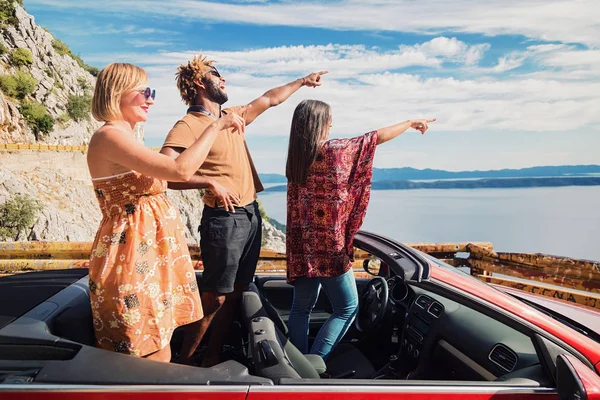 People pointing fingers from convertible — Stock Photo, Image