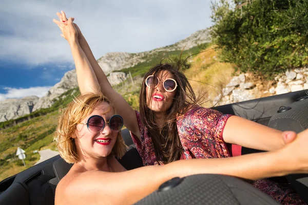 Girls holding hands at convertible — Stock Photo, Image