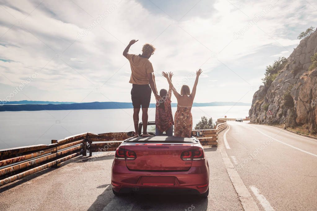  people waving from the convertible