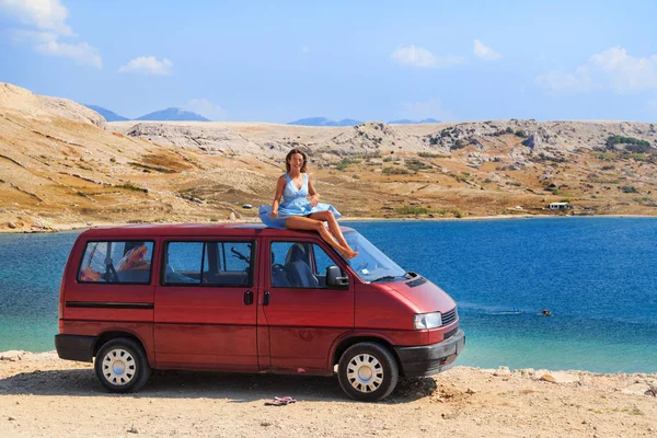 Ragazza seduta su un tetto di furgone — Foto Stock