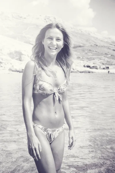 Belle fille bronzée dans un bikini debout dans une eau — Photo