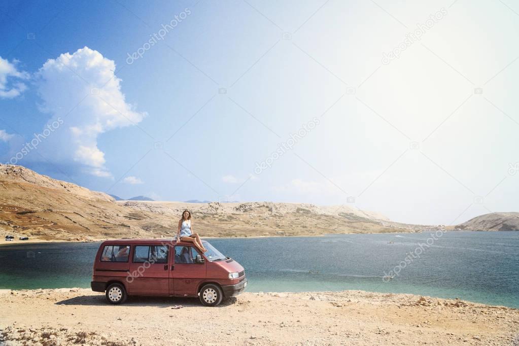 Beautiful tanned girl on a rooftop of a red van