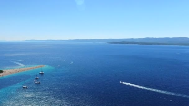 Motorboten passeren de strand Zlatni rat — Stockvideo