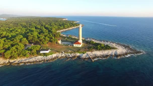 Phare avec un bateau à moteur passant par le sentier de l'eau — Video