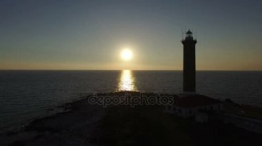 Önünde bir deniz feneri güneş aşağı ayarı