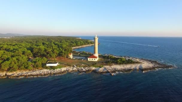 Lighthouse with a motorboat passing by water trail — Stock Video