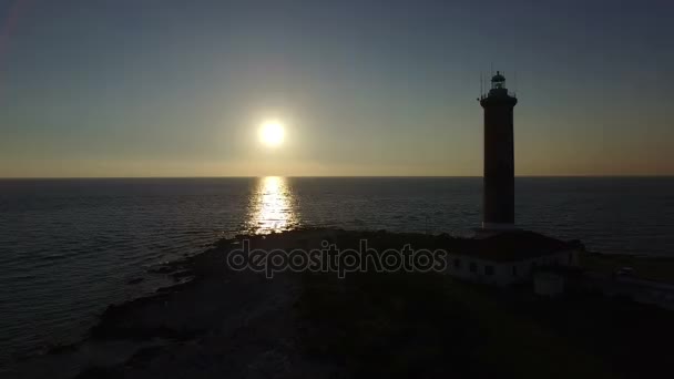 Pôr do sol na frente de um farol — Vídeo de Stock