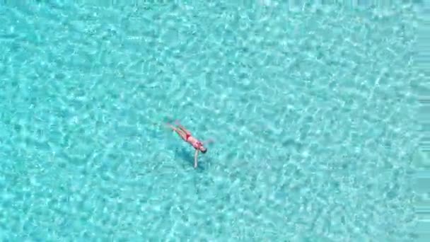 Mujer flotando en el mar cristalino — Vídeo de stock