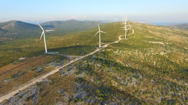 Turbinas eólicas em colinas verdes ensolaradas — Vídeo de Stock