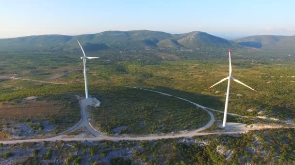 Turbinas eólicas em colinas verdes iluminadas pelo sol — Vídeo de Stock