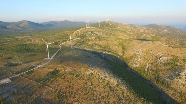 Molinos de viento blancos en un sendero de colina — Vídeo de stock