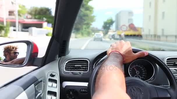Hombre sosteniendo la mano izquierda en el volante del coche — Vídeo de stock