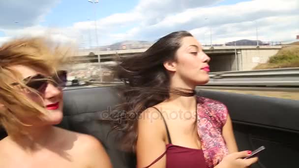 Femmes chevauchant sur le siège arrière de décapotable — Video