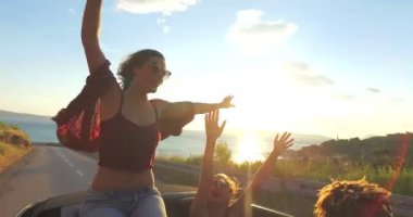 Cabrio araba kaputa oturan esmer