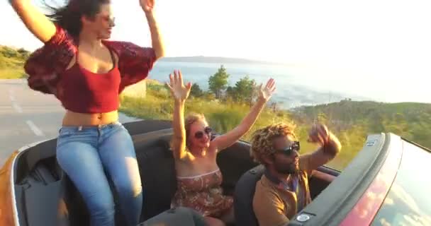 Woman sitting on hood of convertible car — Stock Video