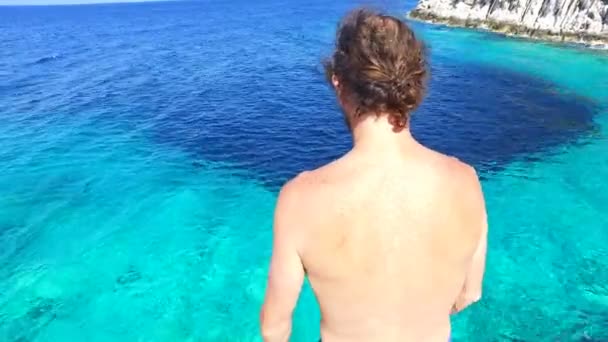 Hombre saltando en el mar turquesa — Vídeos de Stock