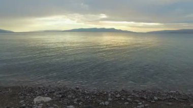 Deniz ve çakıl plaj gün batımında