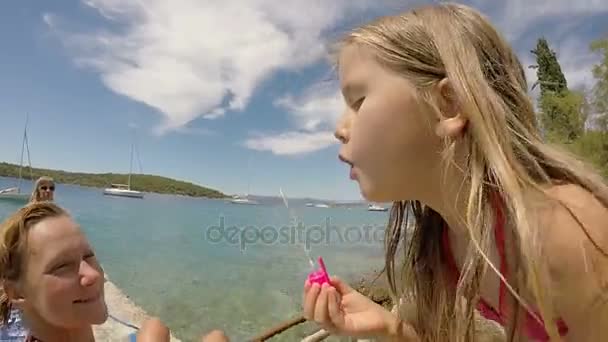 Fille soufflant des bulles sur la plage — Video
