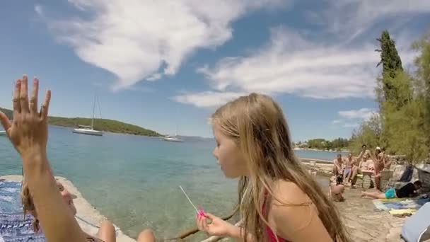 Menina soprando bolhas na praia — Vídeo de Stock