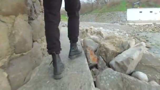 Pessoa caminhando com botas ao longo da praia — Vídeo de Stock