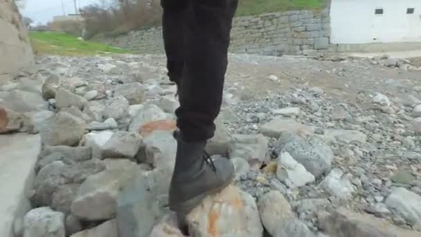 Person läuft mit Stiefeln am Strand entlang — Stockvideo