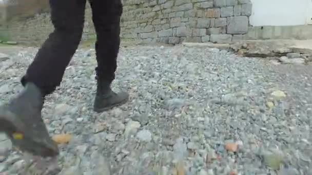 Pessoa caminhando com botas ao longo da praia — Vídeo de Stock