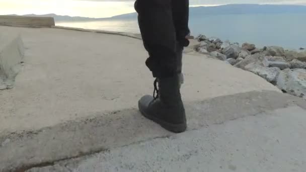 Pessoa caminhando com botas ao longo da praia — Vídeo de Stock