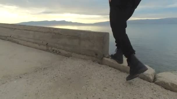 Person läuft mit Stiefeln am Strand entlang — Stockvideo