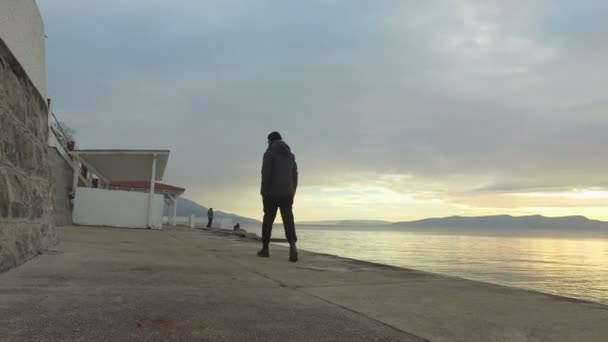 Man walking along seafront walkway — Stock Video