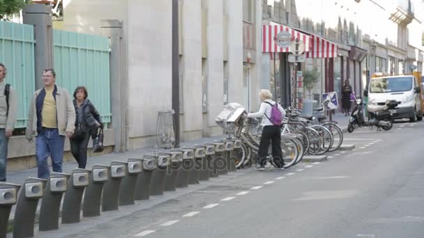 Mulher estacionamento bicicleta na estação de bicicleta — Vídeo de Stock